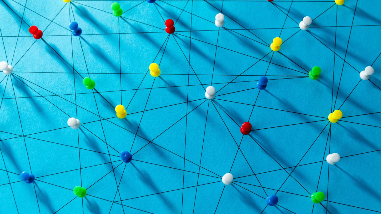 Colorful pins connected by strings in a network showing how continuous localization links code repos to translation workflows