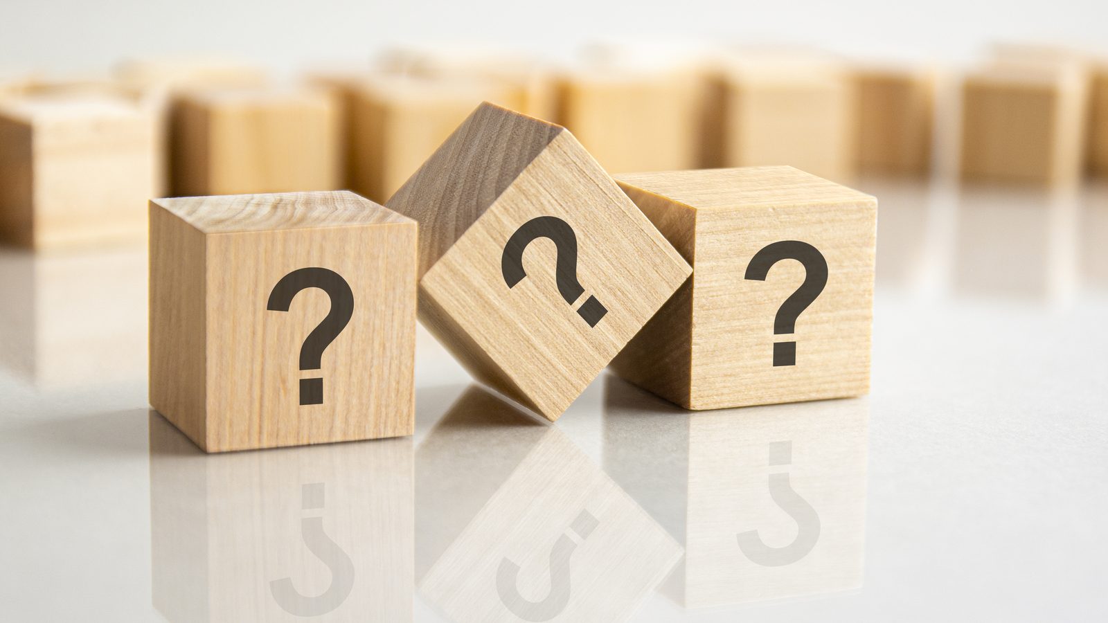 Three wooden cubes marked with question marks representing the three kinds of subject matter experts that localization programs rely on
